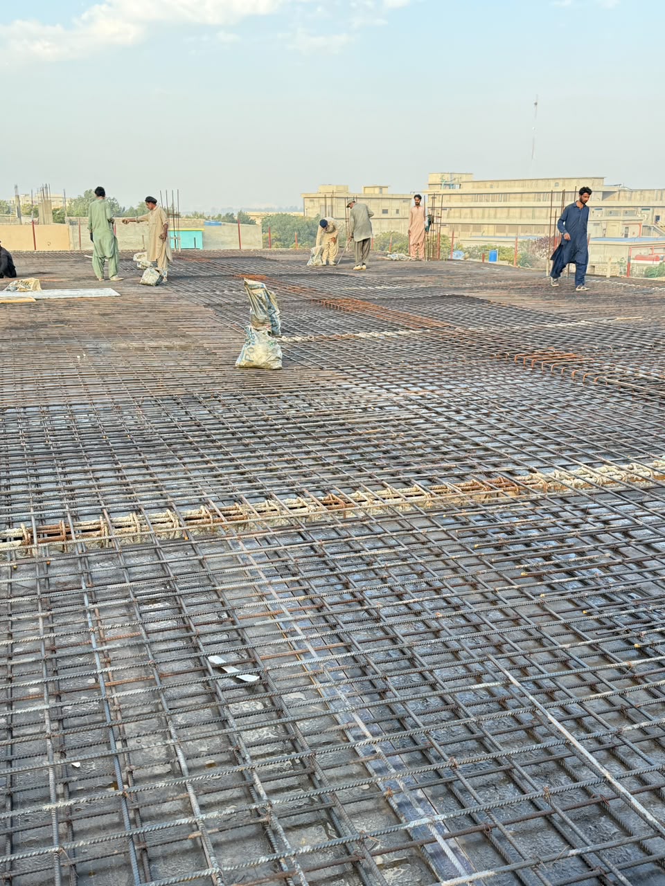 Civil crew working on a rebar-reinforced concrete roof deck
