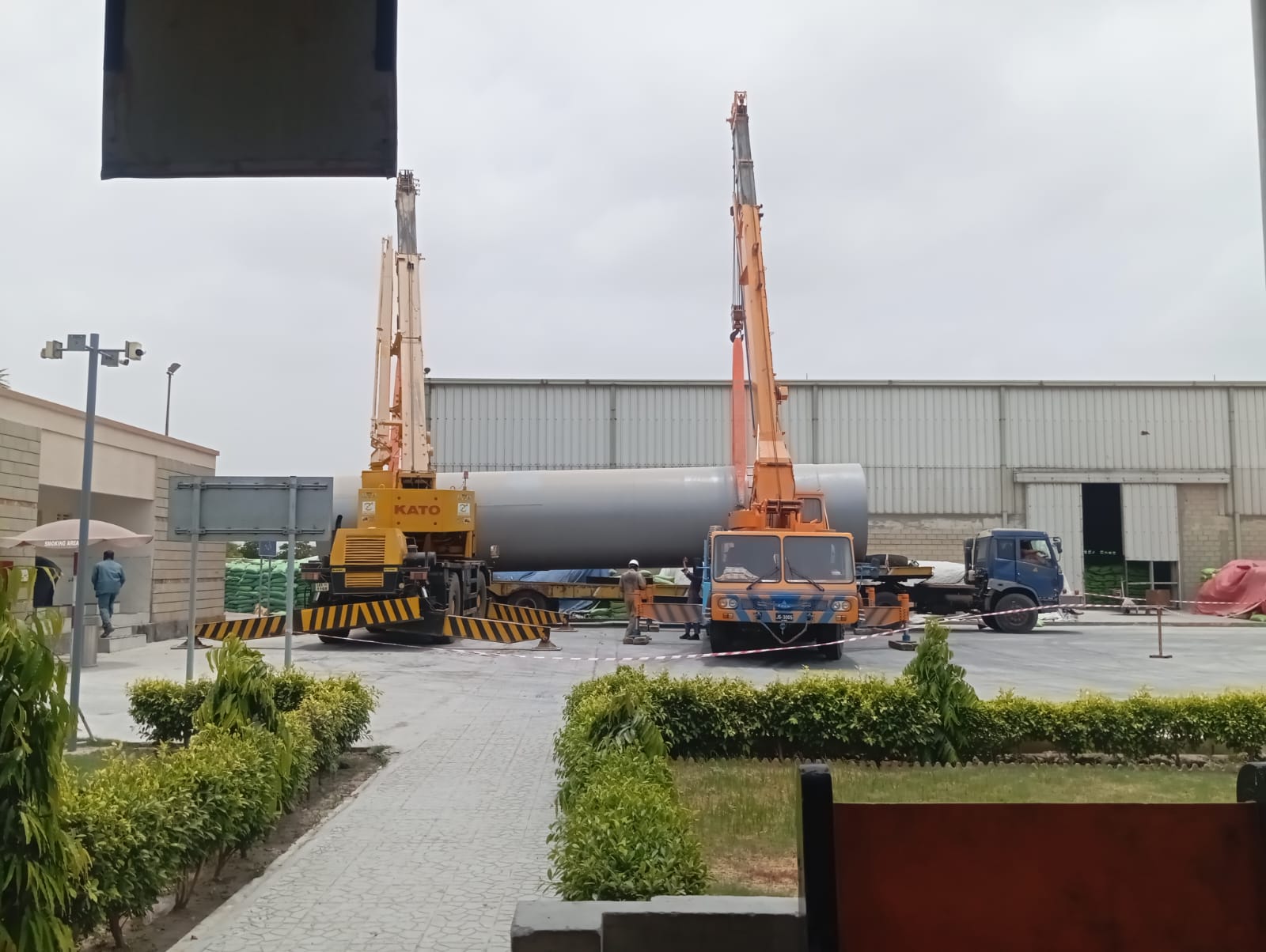 Two mobile cranes performing a tandem lift at a plant facility